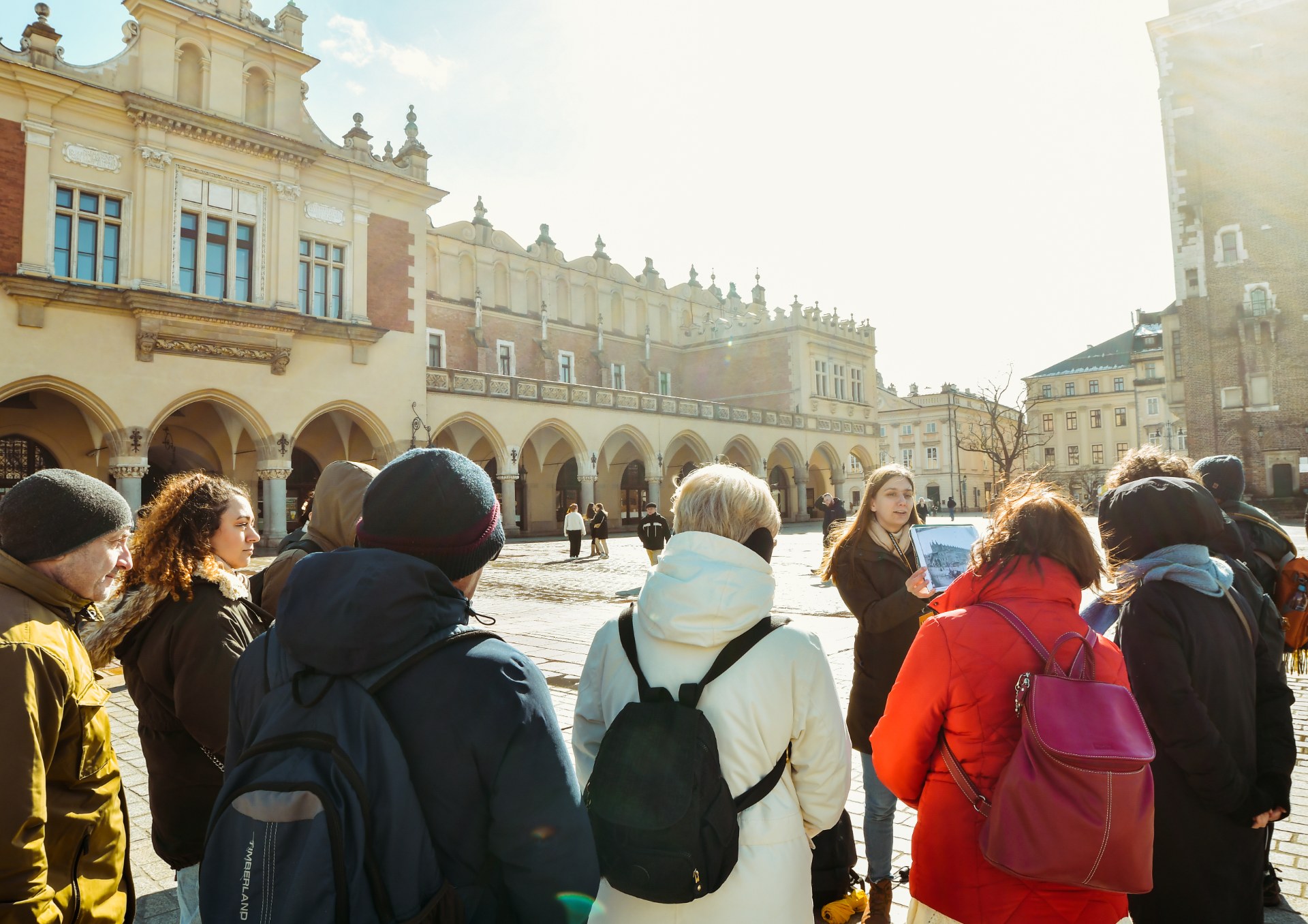 Un groupe de jeunes avec une guide sur la place du Marché de Cracovie
